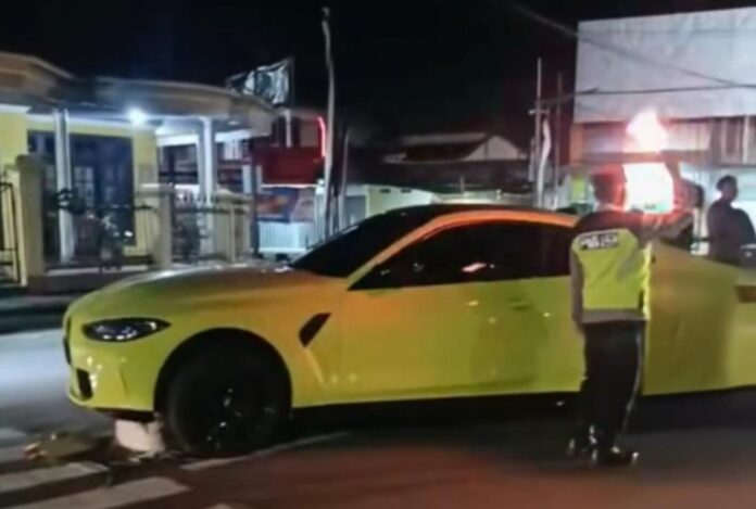 Penampakan mobil mewah bmw coupe terjang marka pembatas jalan. Foto: Tangkapan Layar (Medsos)